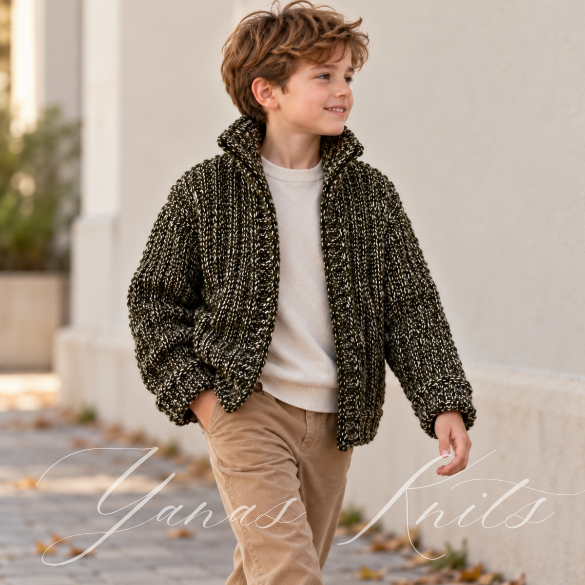 Child wearing a chunky dark olive marl ribbed cardigan outdoors