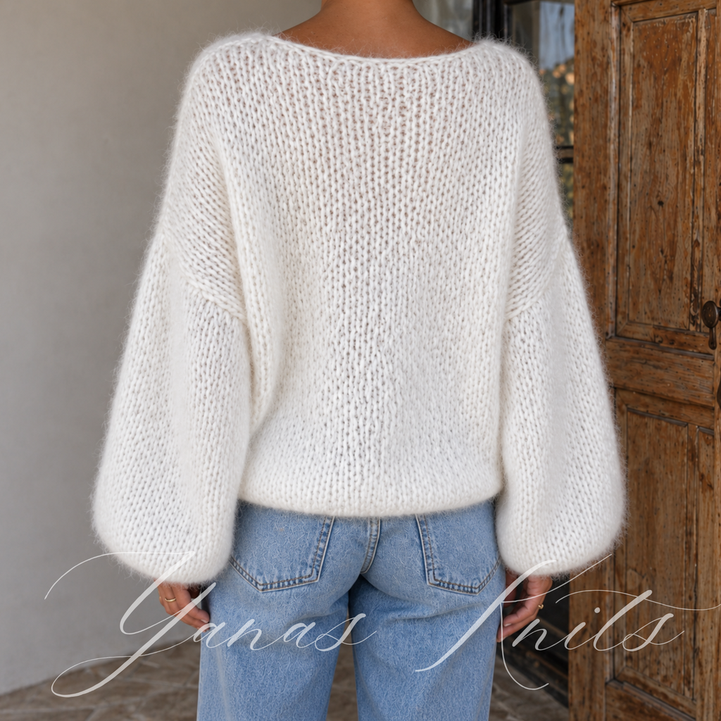 Back detail of an airy ivory sweater showing its drop shoulder shape and soft knitted texture