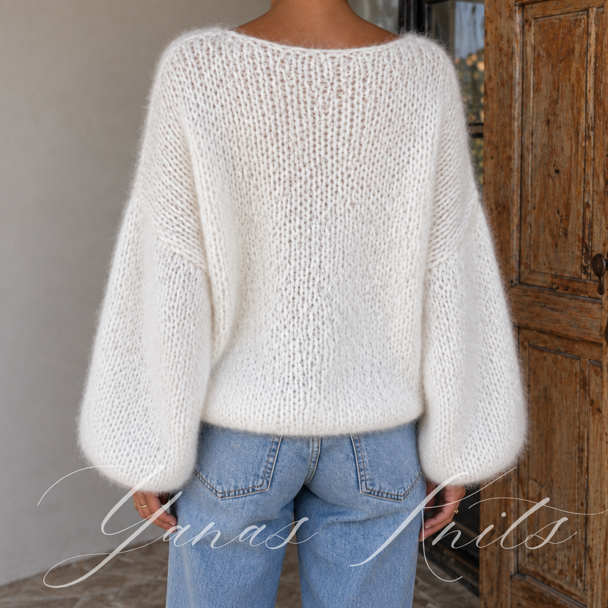 Back detail of an airy ivory sweater showing its drop shoulder shape and soft knitted texture