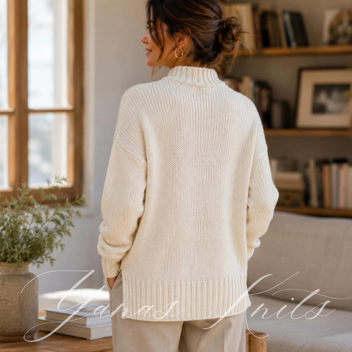 Back view of an ivory longline knitted sweater with dropped shoulders and a broad ribbed hem